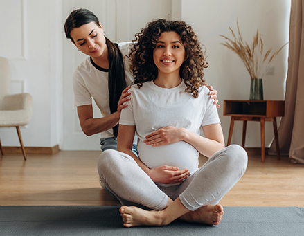 Gestante faz exercício com apoio profissional em ambiente tranquilo.