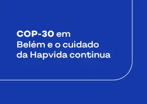 Três pessoas sorrindo, representando o modelo de saúde integrado da Hapvida, uma médica, uma paciente e um médico, lado a lado.