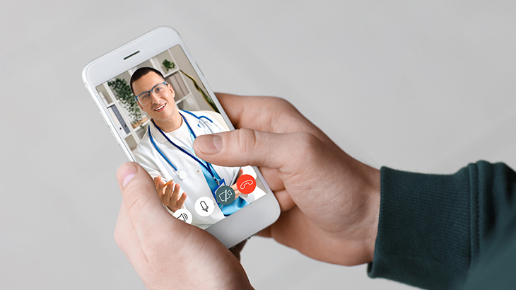 Pessoa realizando teleconsulta pelo celular com médico em videochamada.