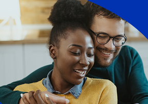 Casal sorrindo olhando celular juntos em momento descontraído