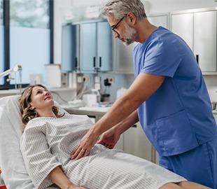 Médico examinando o abdômen de uma paciente deitada em uma maca, com expressão séria, ilustrando uma consulta médica sobre aborto espontâneo.