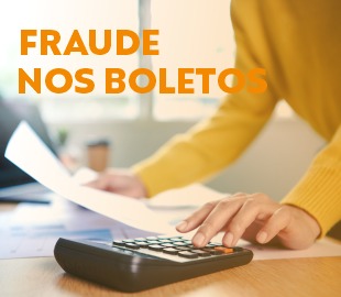 Mãos de uma pessoa usando uma calculadora e segurando um documento sobre uma mesa, com a frase FRAUDE NOS BOLETOS sobreposta, simbolizando o alerta para não cair em golpes de boletos falsos.