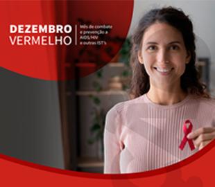 Mulher sorrindo, segurando uma fita vermelha de conscientização, com a frase DEZEMBRO VERMELHO em um fundo vermelho e preto, simbolizando a campanha de combate e prevenção ao HIV/AIDS.