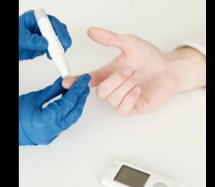 Mãos usando luvas azuis para realizar um teste de glicemia no dedo de uma pessoa, com um glicosímetro em primeiro plano, simbolizando a medição de diabetes.
