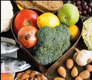 Variedade de alimentos saudáveis (brócolis, tomate, cebola, limão, maçã, peixe, amêndoas, alho) em uma bandeja em formato de coração, simbolizando uma dieta balanceada para o controle do diabetes.