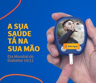 Glicosímetro na mão de uma pessoa, com a tela exibindo a imagem de um homem bebendo água, e a frase A sua saúde tá na sua mão, simbolizando o controle do diabetes no Dia Mundial do Diabetes.
