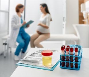 Exames de urina e sangue prontos para análise em consultório, com gestante em atendimento médico ao fundo, simbolizando o cuidado pré-natal