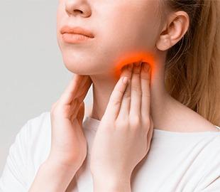 Mulher tocando o pescoço e a garganta, com uma área vermelha destacada indicando dor ou inchaço nos gânglios linfáticos, simbolizando sintomas de mononucleose.