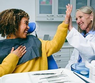 Dentista sorridente cumprimenta paciente em consultório moderno, celebrando o sucesso de um tratamento odontológico e uma experiência positiva