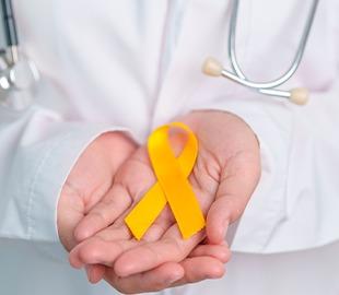 Mãos de um profissional de saúde, de jaleco branco com estetoscópio, segurando uma fita amarela, simbolizando a campanha Setembro Amarelo e a importância de pedir ajuda para cuidar da saúde mental.