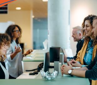 Funcionários de um balcão de atendimento conversando com um cliente, simbolizando a nova forma de atendimento em Florianópolis.