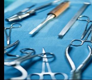 Instrumentos cirúrgicos dispostos em um campo cirúrgico azul, simbolizando o contexto médico de cirurgias, como a bariátrica, e seus impactos emocionais.