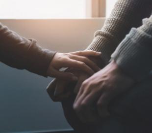 Mãos de duas pessoas se tocando e se segurando, simbolizando apoio, conforto e solidariedade, relacionados ao Setembro Amarelo e à discussão sobre depressão.
